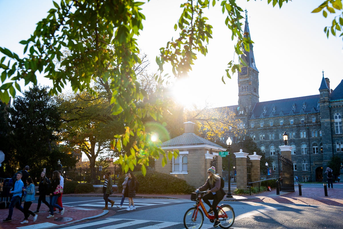 The main gates of Georgetown University and sunset, featuring the gatehouse and Healey Hall