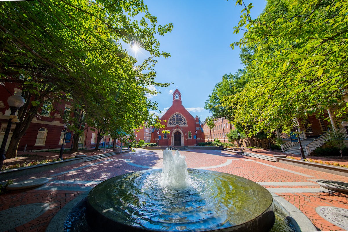 The exterior of Dahlgren Chapel featuring the courtyard, fountain, and trees.