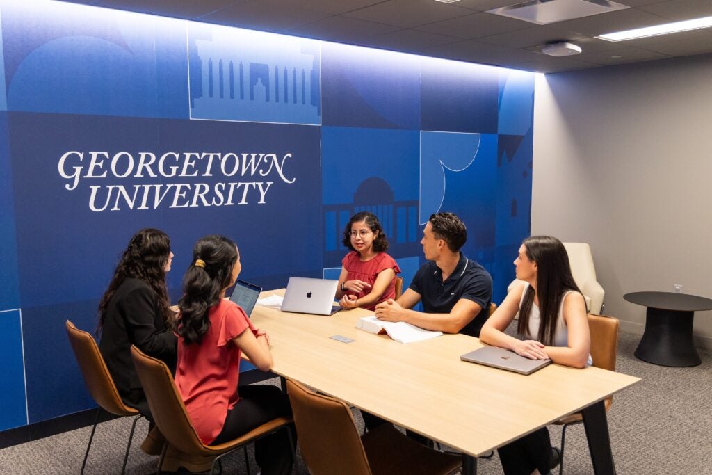 Students having a discussion at a table in the student affairs lounge