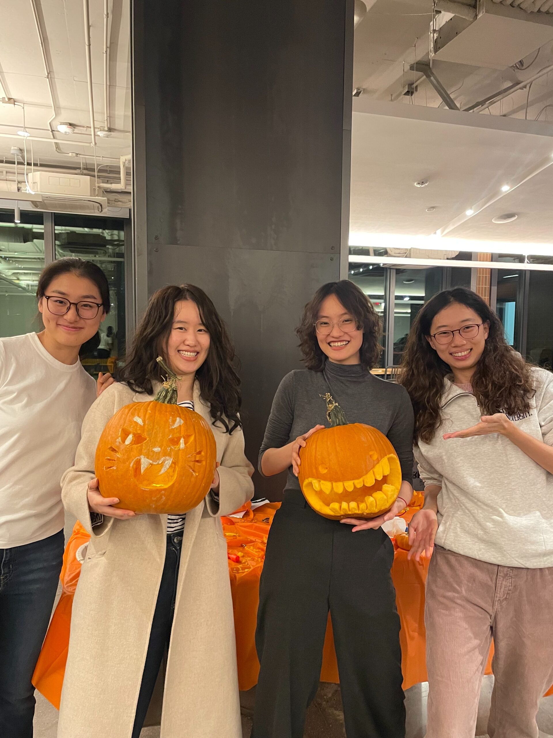 Four students holding up pumpkins at the pumpkin palooza event